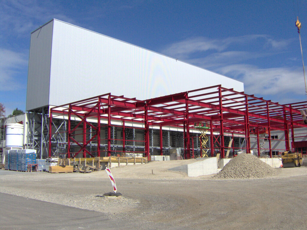 Neubau der Halle und Speditionshalle Müller Martini in der Farbe Grau mit rot.